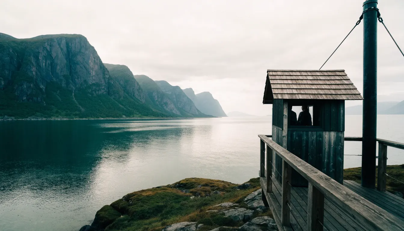 Norsk fjord med en liten lukket tilsynsbu ved utkikspunktet